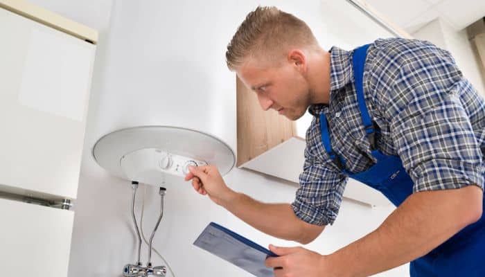 Technician adjusting water heater settings during installation