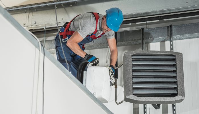 Fastest Heating Installation Option During Winter. in Essex HVAC technician installing a fast heating system during winter inside a commercial building